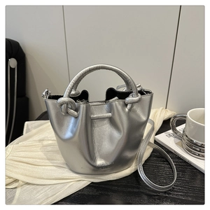 Close-up of metallic silver pleated bucket bag with EUFD & BAG lettering and top handle