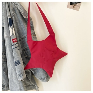 Détail du sac bandoulière en toile rouge en forme d'étoile avec coutures matelassées