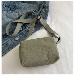 Detail of sage green nylon crossbody bag with unique wrinkled texture and adjustable strap