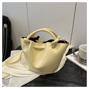 Detailed close-up of cream pleated bucket bag with twisted handles and FUFD logo