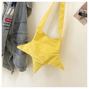 Detail shot of a yellow star-shaped crossbody bag with soft nylon fabric and shoulder strap