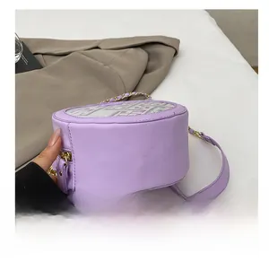 Detail of lavender round bag showing smooth faux leather sides and metal chain strap