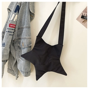 Detail of a black star-shaped crossbody bag made of quilted nylon on a white background