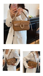 Detail of vintage brown baguette bag featuring a stylish golden horseshoe metal buckle