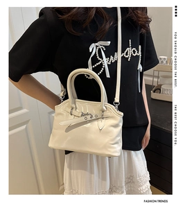 Sac bandoulière blanc crème tendance avec boucle croisée porté avec une tenue élégante