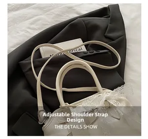 Détail de la bandoulière en cuir réglable et du nœud en dentelle du sac blanc