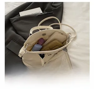 Intérieur spacieux du sac coquille blanc cassé montrant les essentiels avec fermoir aimanté