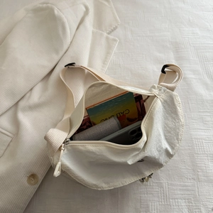 Minimalist white nylon crossbody bag with adjustable strap and spacious interior