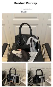 Vue détaillée du sac en cuir noir brillant orné d'un nœud décoratif en dentelle blanche