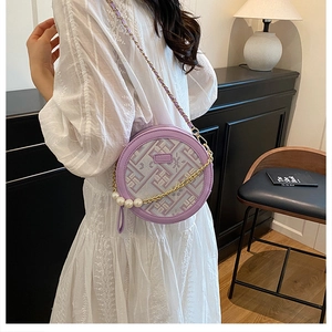 Vue détaillée du sac rond lilas avec bandoulière perle et motif géométrique moderne