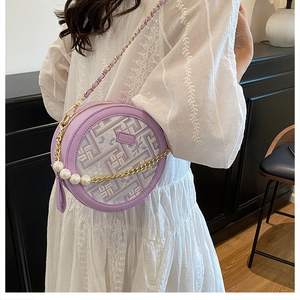 Détail d'un petit sac rond lavande tissé avec chaîne en perles et broderie