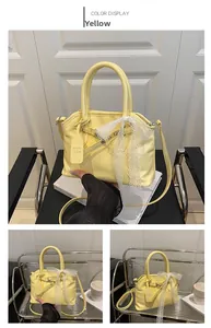 Détail du sac coquillage jaune avec nœud en dentelle blanche et étiquette de marque en cuir