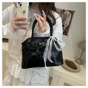 Sac à main noir brillant avec nœud en dentelle blanche et bandoulière réglable