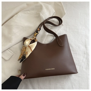 Détail du sac cabas marron avec coutures blanches et écharpe en soie vintage nouée
