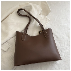 Détail d'un sac cabas caramel avec surpiqûres blanches et poignées foulard en soie