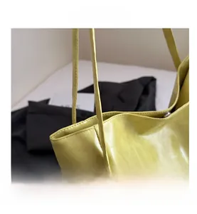Detailed close-up of light green PU leather tote bag with fine stitching and slim strap