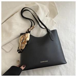 Détail du grand cabas en cuir noir avec surpiqûres et poignée ornée d'un foulard en soie