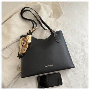 Détail d'un sac cabas en cuir noir avec surpiqûres blanches et foulard en soie décoratif
