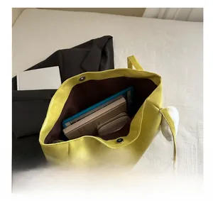 Interior view of large yellow tote bag showing high capacity for tablets and books