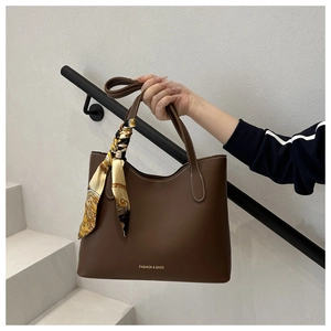 Détail d'un sac cabas marron café avec surpiqûres blanches et foulard en soie au manche