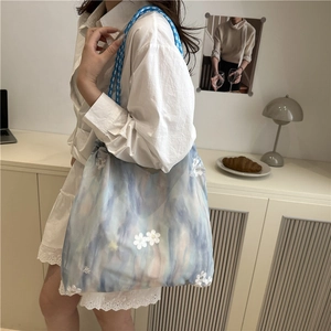 Blue tie-dye tote bag with floral embroidery and braided rope shoulder straps