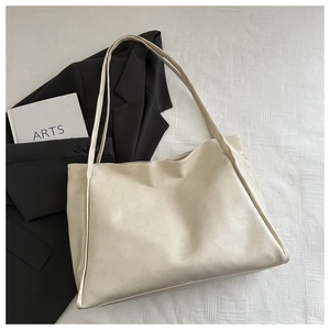 Dettaglio della borsa tote minimalista bianco avorio con trama in pelle e tracolla lunga