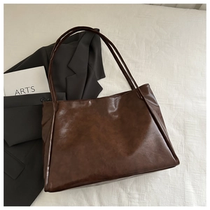 Dettaglio della borsa tote marrone scuro con trama cerata e sottili spalline in ecopelle