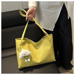 Dettaglio borsa shopper gialla con ciondolo a nuvola e trama in pelle martellata