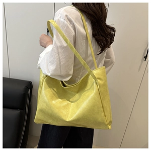 Dettaglio della grande borsa tote gialla in morbida pelle con finitura vintage