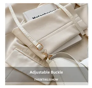 Close-up of adjustable metal buckle and stitching on white shoulder bag strap