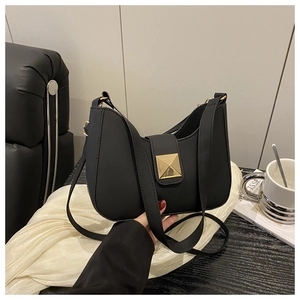Detailed view of black matte saddle bag featuring a gold square buckle and adjustable strap