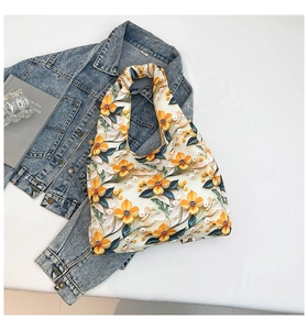 Detailed top view of a white tote bag with 3D floral prints on blue denim fabric