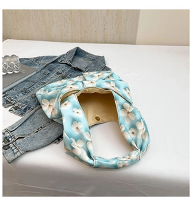 Detail of light blue floral fabric tote bag with magnetic clasp and beige lining