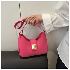 Detail of hot pink crescent hobo bag with gold pyramid buckle and smooth matte leather