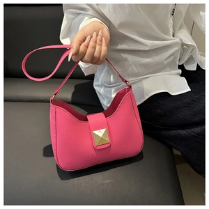 Detail of rose pink hobo bag featuring a large gold Roman Stud and smooth leather finish
