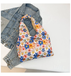 Detailed close-up of colorful daisy floral embroidery on casual canvas tote bag