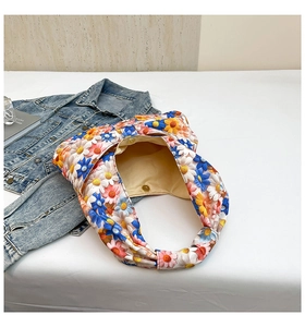 Detail of floral tote bag showing colorful 3D daisy patterns and magnetic gold clasp