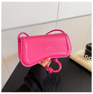 Detailed view of magenta PU leather handbag with knot handle and XM & BAGS gold logo