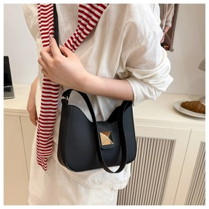 Close-up of a black crescent moon bag with a prominent square gold metal buckle clasp