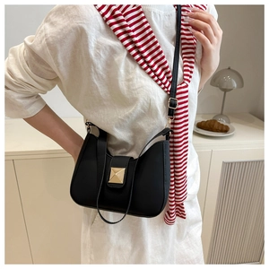 Chic black half-moon shoulder bag with square gold rivet buckle shown in a lifestyle setting