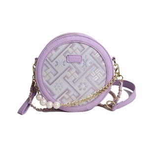 Purple round crossbody bag with pearl chain and floral embroidery on white background