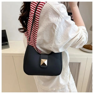 Detailed view of black matte leather shoulder bag with gold square rivet buckle closure