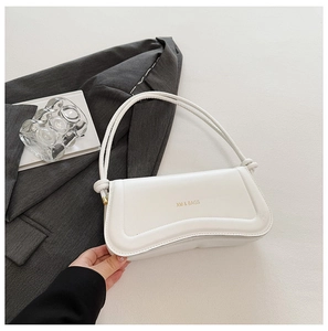 Detailed macro view of white shoulder bag with wave-curve flap and gold XM & BAGS logo