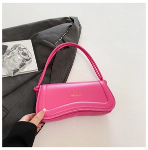 Close-up of wavy bright pink handbag with gold brand logo and glossy leather finish