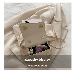 Top view of beige square bag capacity display with makeup items and golden accents