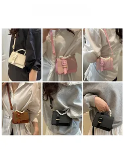 Detail of structured mini crossbody bag with glossy texture and elegant pearl handle