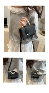 Close-up of black woven square bag with pearl handle and golden metallic hardware details