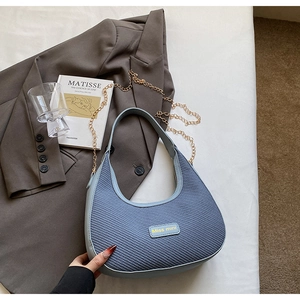 Détail du sac hobo tissé bleu clair avec chaîne dorée et plaque logo Miss mini