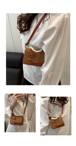 Detail of woven crossbody bag with pearl handle and leather strap on model