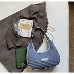 Détail du sac tressé bleu clair avec chaîne dorée et plaque logo Miss mini